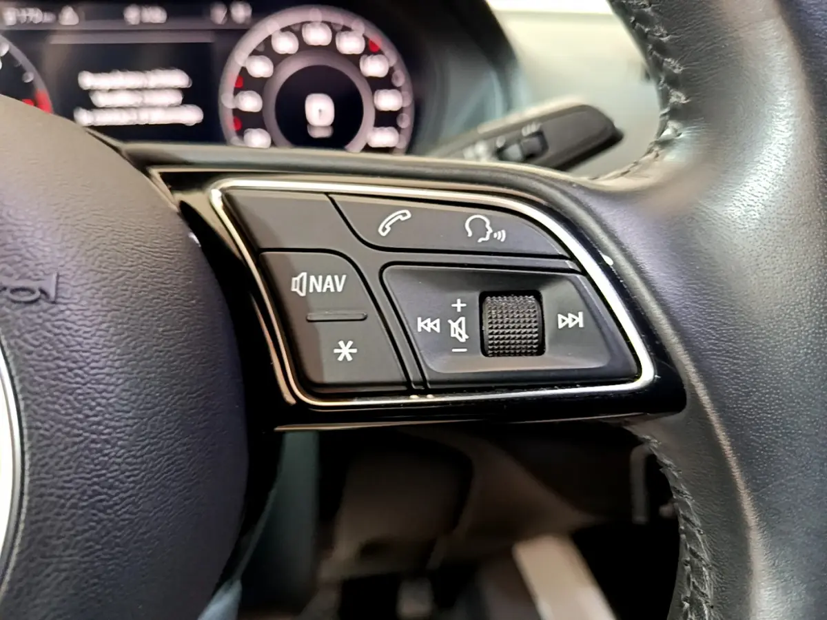 Gros plan sur les commandes multifonctions du volant cuir noir de l'Audi Q2 35 TDI 150 Design 2020.