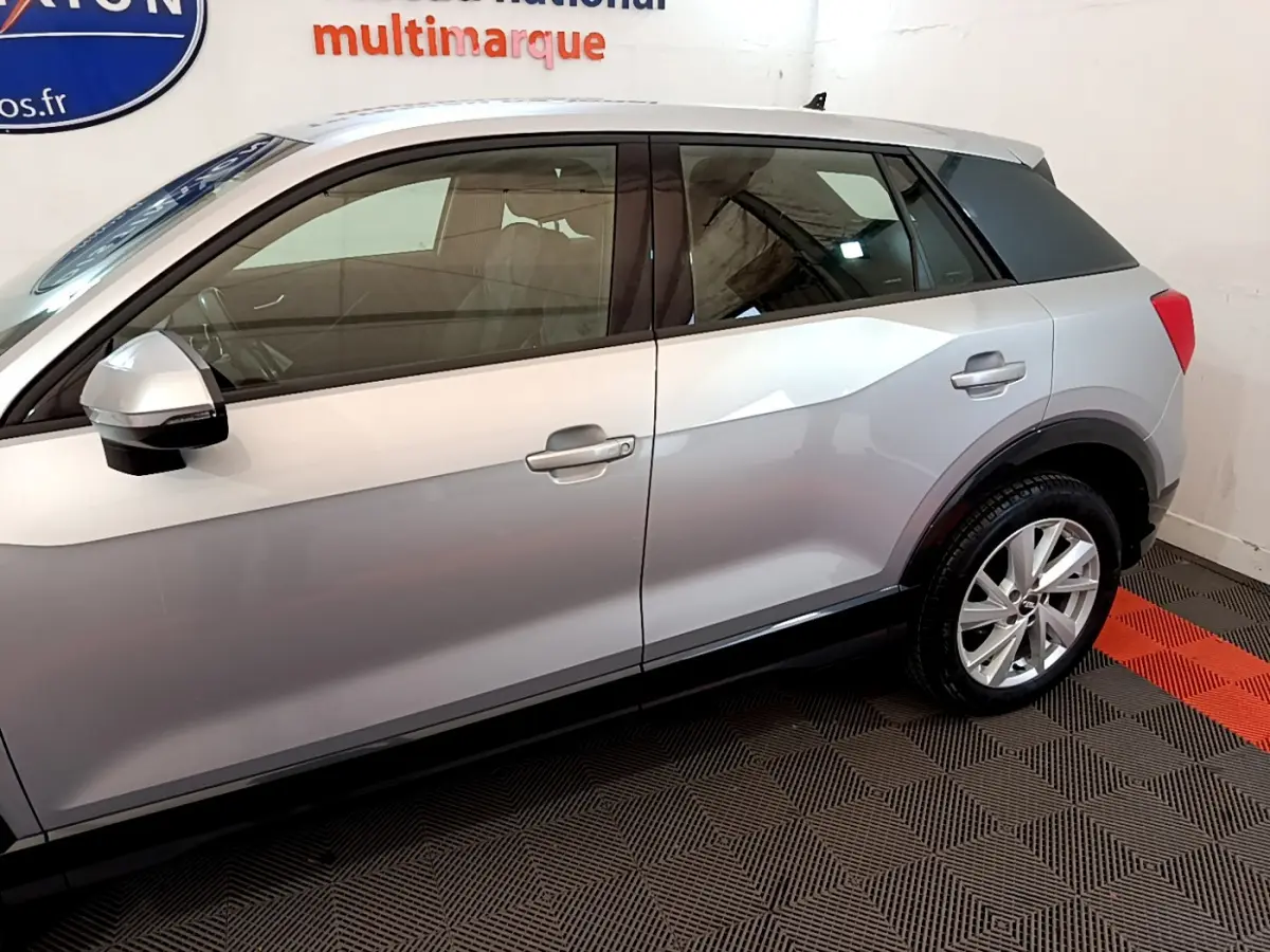 Vue latérale droite d'un Audi Q2 gris clair 2020, soulignant ses lignes anguleuses et ses jantes alliage.