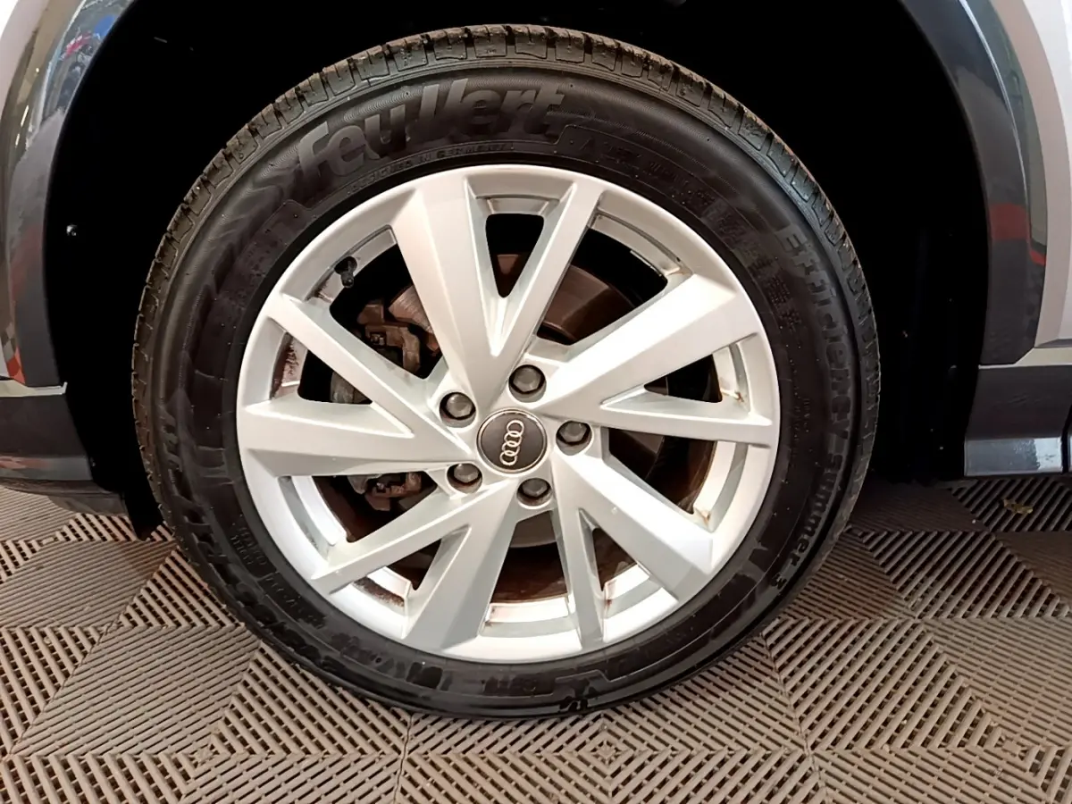Gros plan sur la roue avant droite grise d’un Audi Q2 35 TDI 150 Design avec jante en alliage à 5 doubles branches.