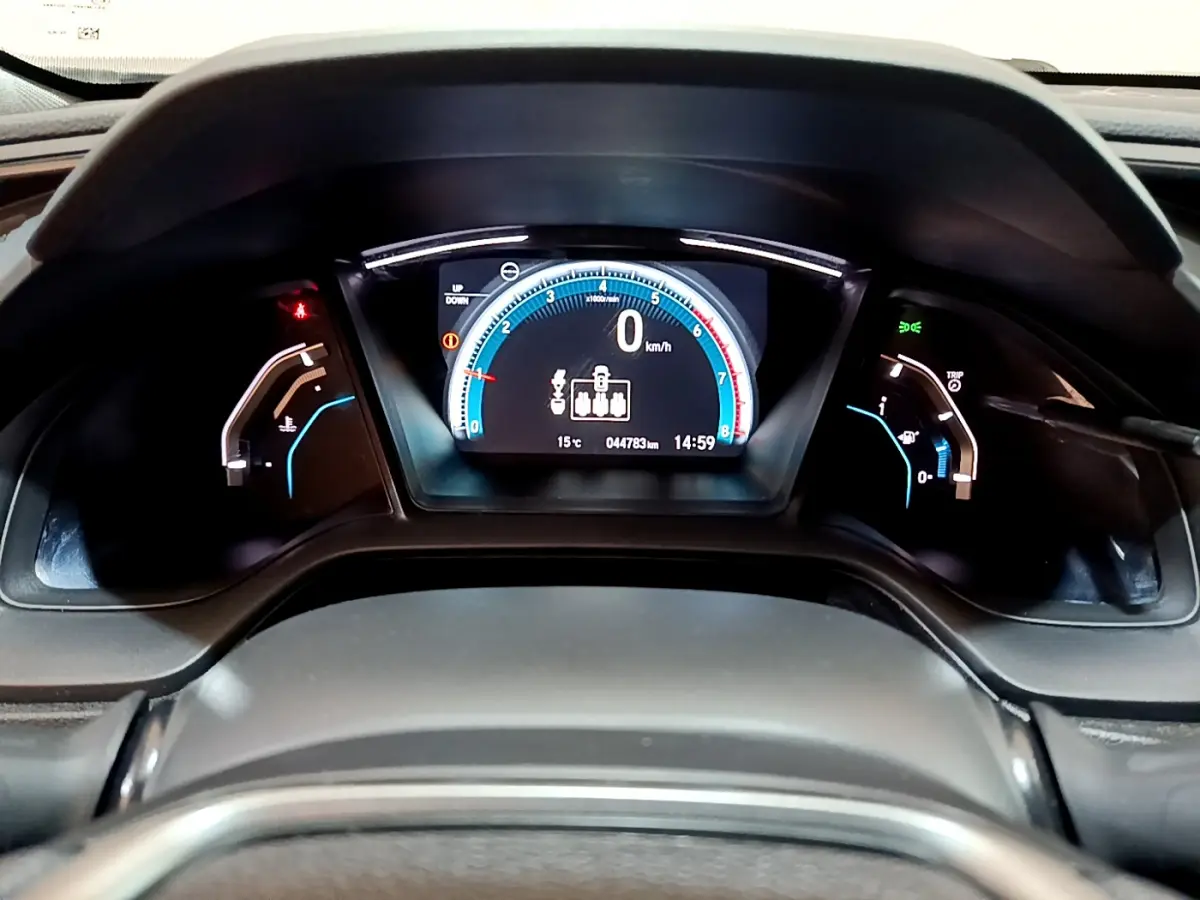 Tableau de bord numérique de la Honda Civic 1.0 i-VTEC Exclusive 2020, affichage vitesse et température, vue frontale rapprochée.