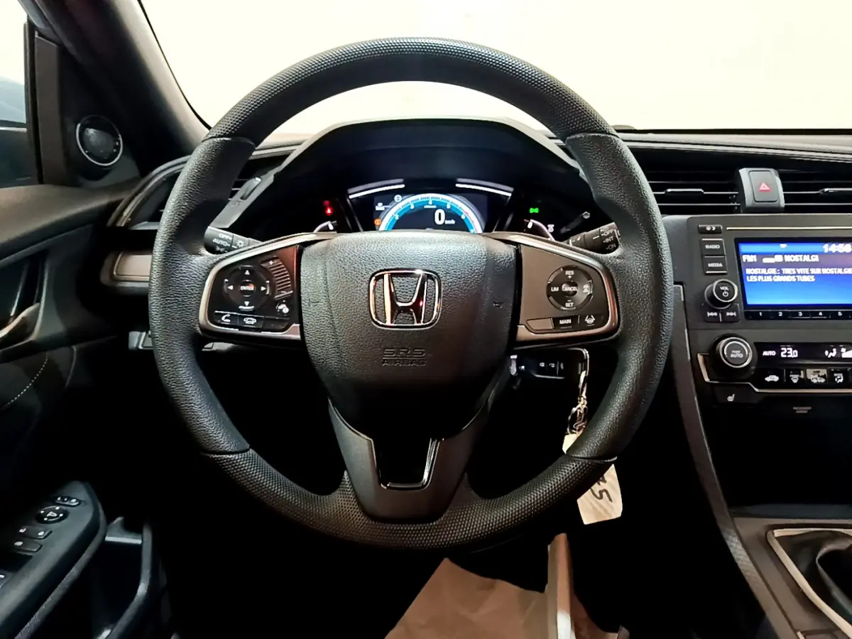Intérieur de la Honda Civic 1.0 i-VTEC Exclusive 2020, vue frontale du volant cuir et tableau de bord digital.