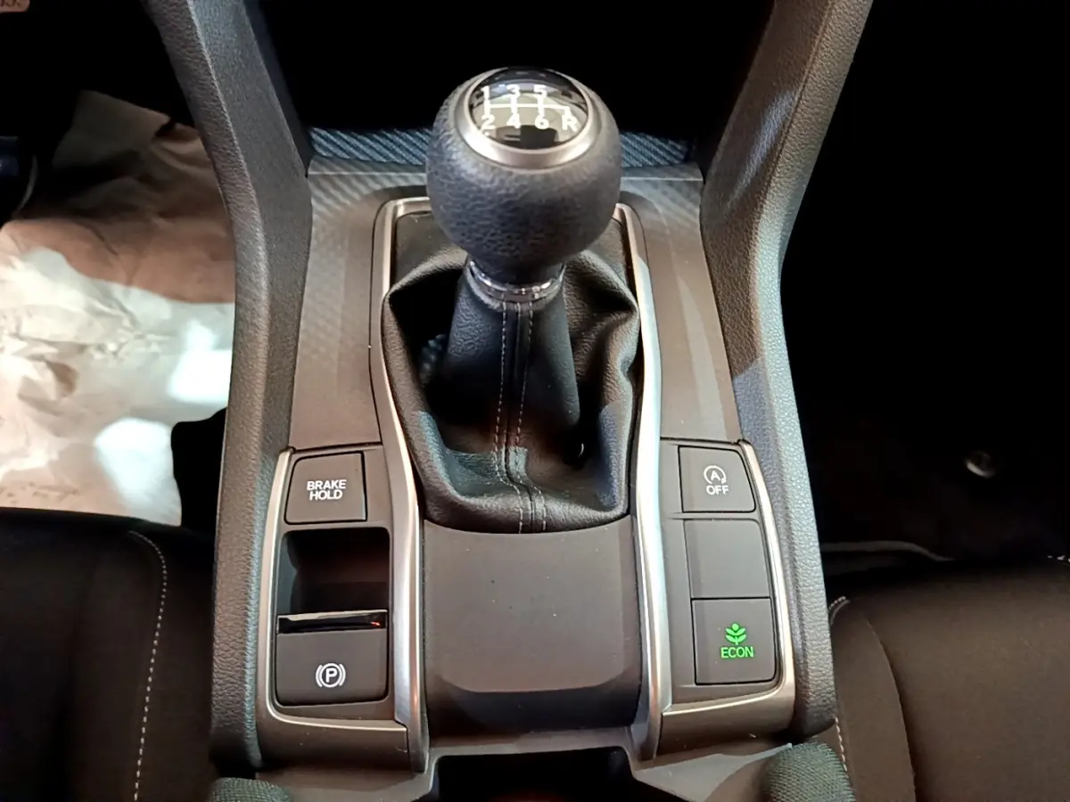 Gros plan sur le levier de vitesse manuel de la Honda Civic 1.0 i-VTEC Exclusive 2020 avec boutons de contrôle autour.