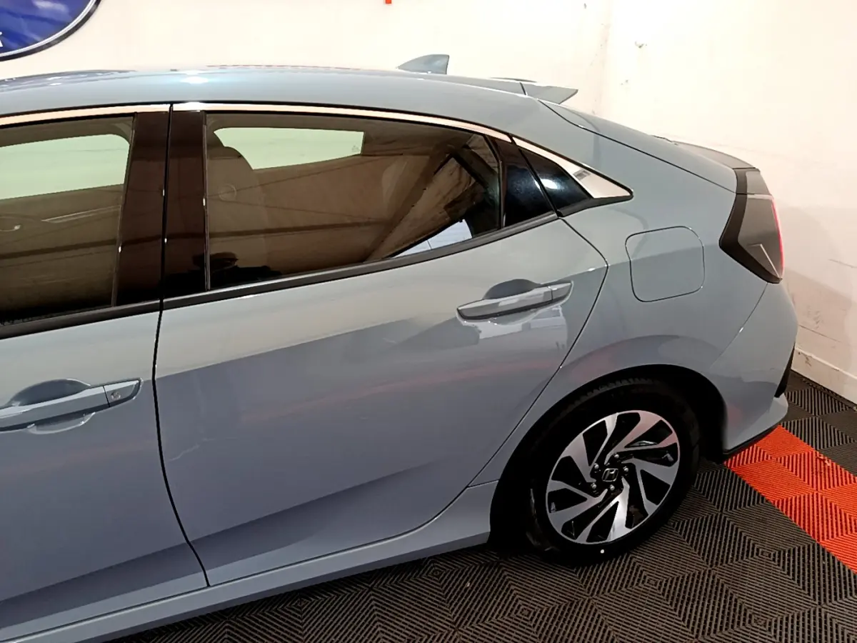 Vue latérale droite de la Honda Civic 1.0 i-VTEC Exclusive gris foncé, mettant en valeur les jantes alliage et la ligne de toit dynamique.