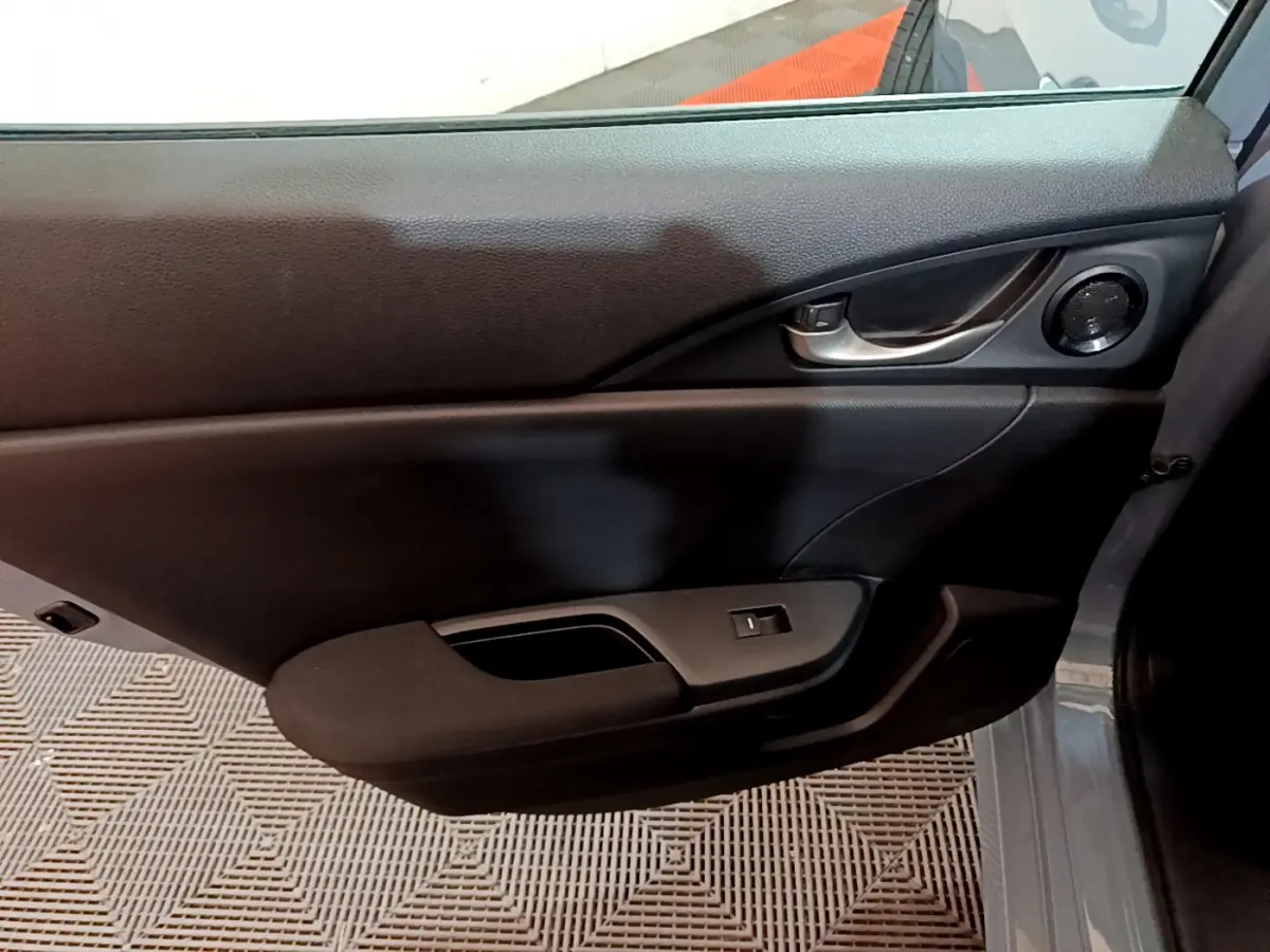 Gros plan sur la porte intérieure côté droit de la Honda Civic 1.0 i-VTEC Exclusive gris foncé avec poignée et haut-parleur intégrés.