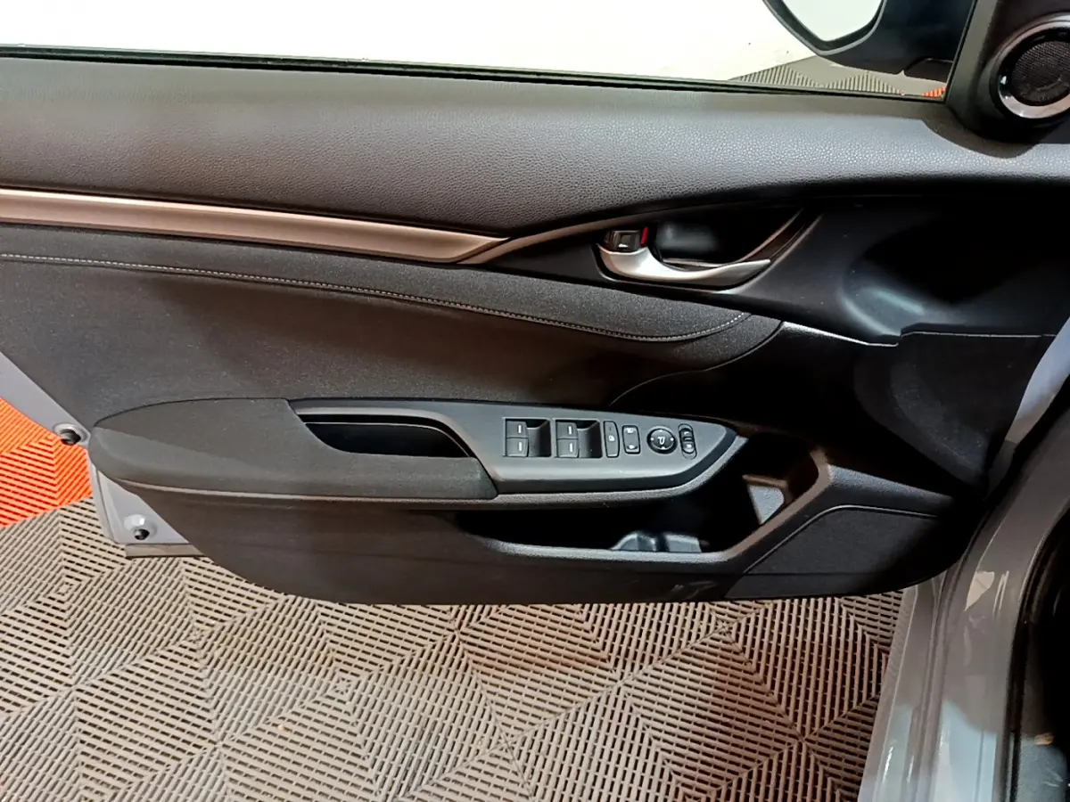 Porte côté conducteur de la Honda Civic gris foncé 2020, avec commandes électriques des vitres et rétroviseurs intégrés.