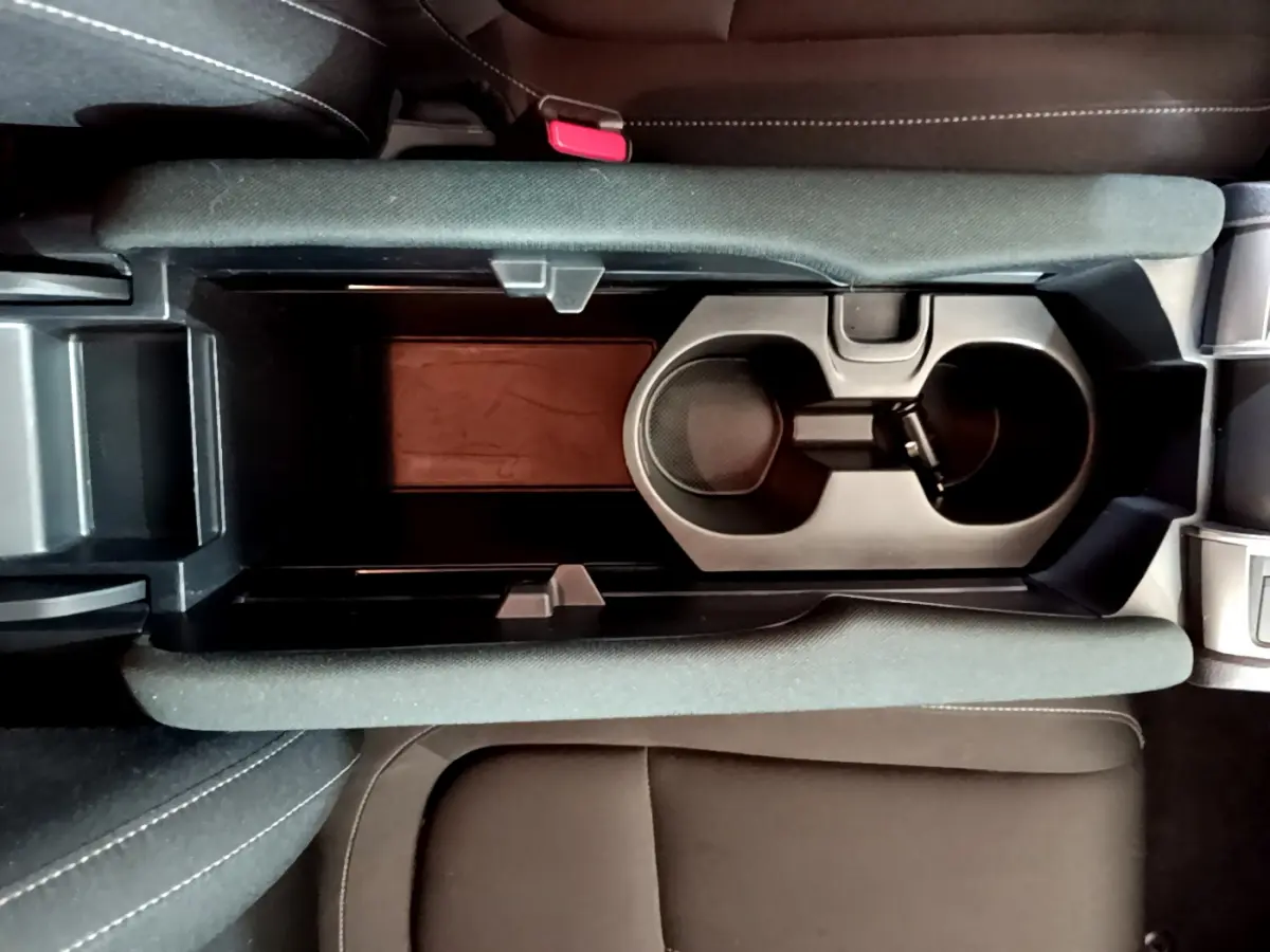 Vue plongeante sur la console centrale noire avec porte-gobelets et accoudoirs en tissu de la Honda Civic gris foncé 2020.