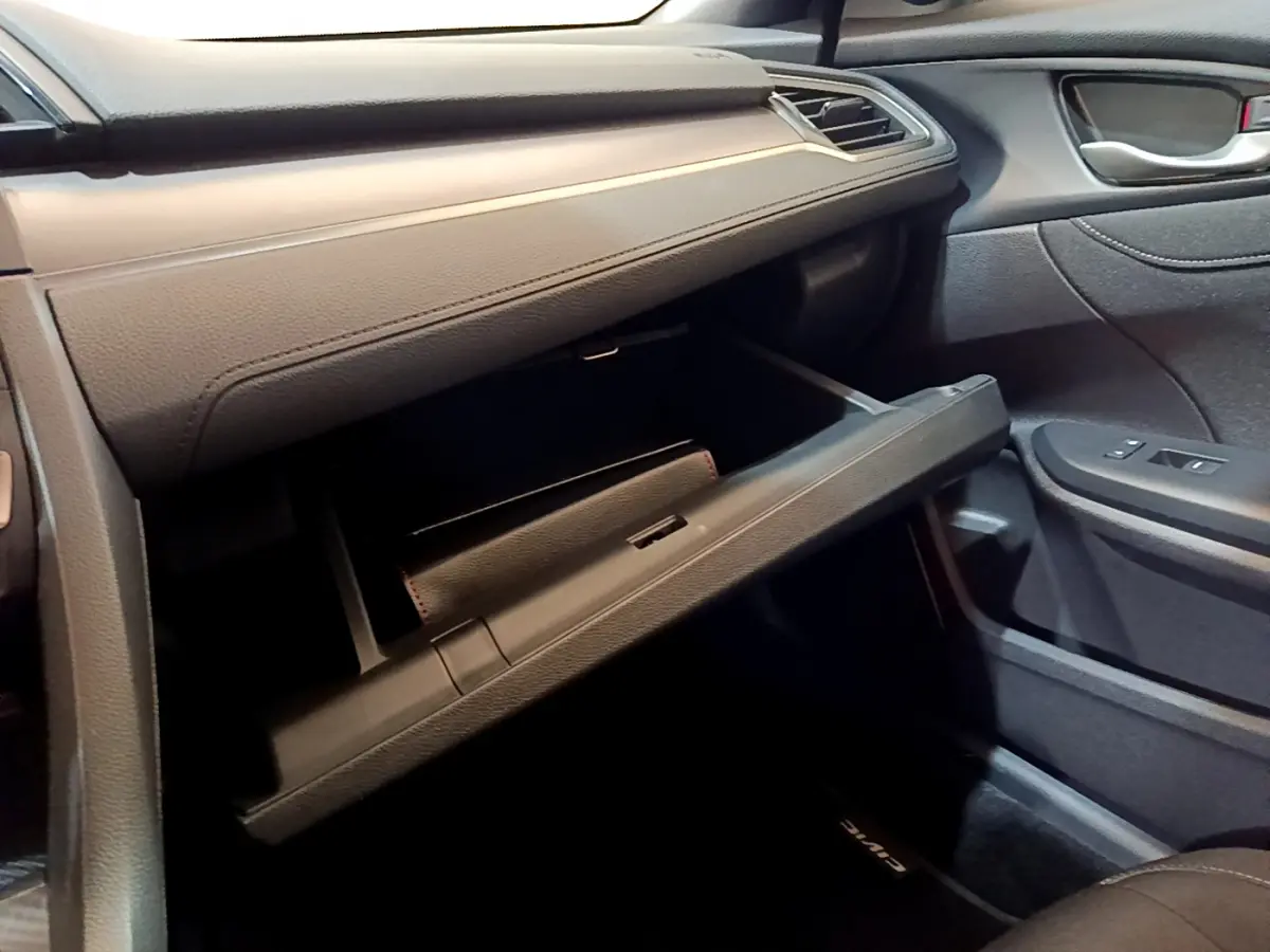Intérieur côté passager de la Honda Civic 1.0 i-VTEC Exclusive 2020, boîte à gants ouverte et garnitures noires.