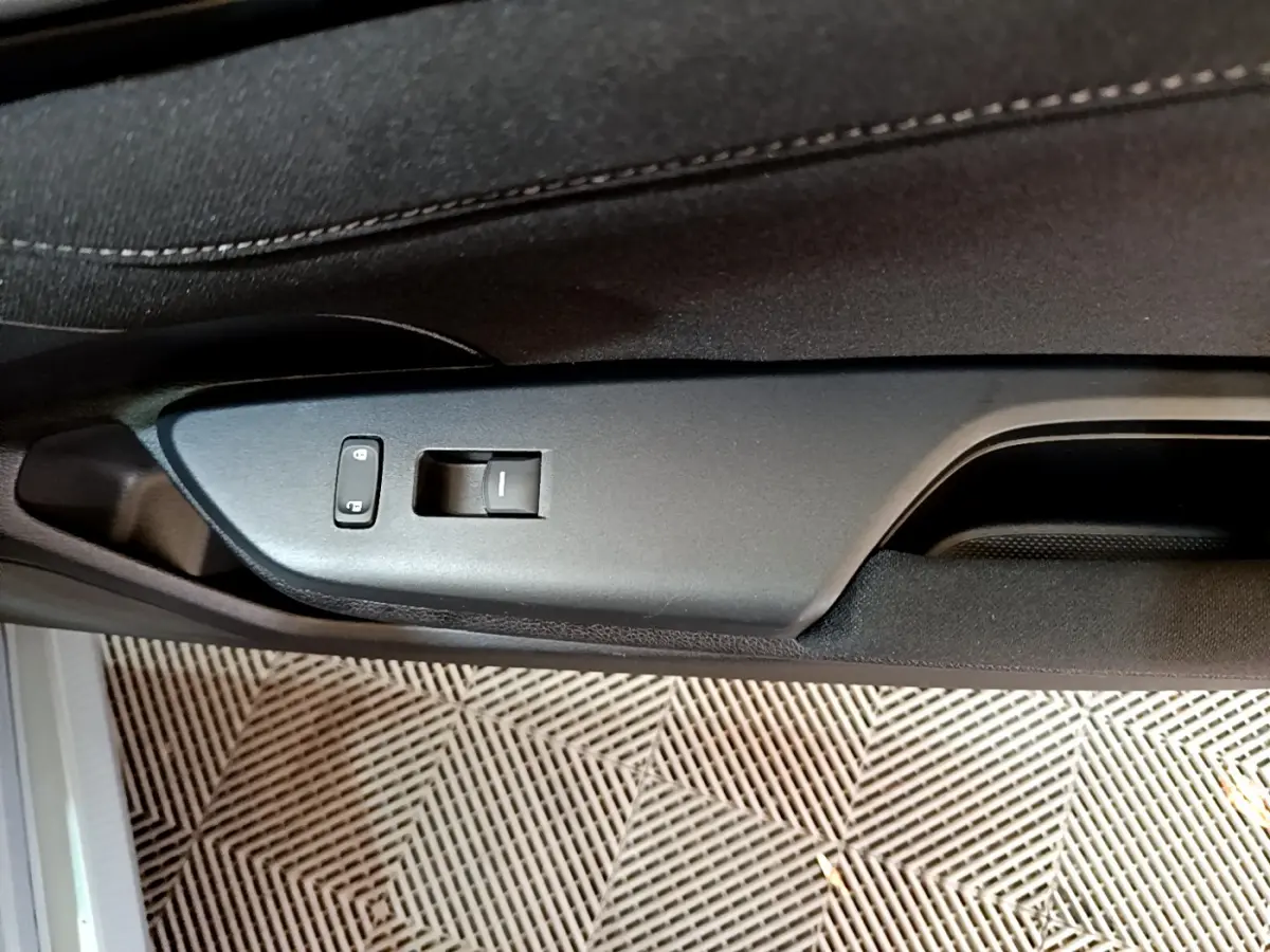 Gros plan sur la commande de verrouillage et lève-vitre côté gauche de la porte intérieure noire d'une Honda Civic gris foncé 2020.