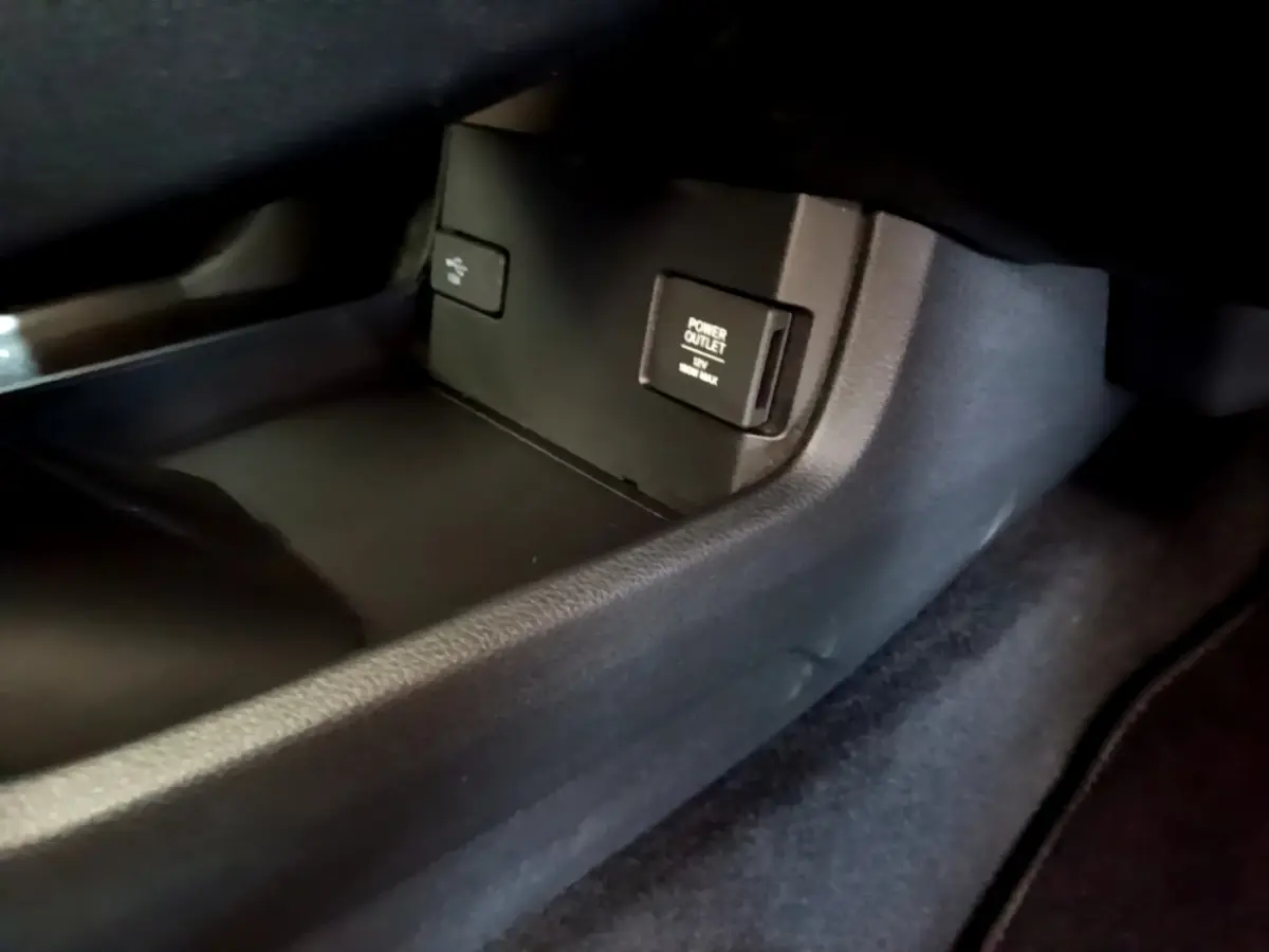 Prise 12V et port USB dans le compartiment central de la Honda Civic 1.0 i-VTEC Exclusive gris foncé, vue intérieure côté passager.