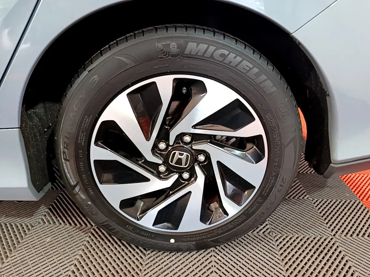 Gros plan sur la roue avant droite grise d'une Honda Civic 1.0 i-VTEC Exclusive avec jante alliage distinctive.