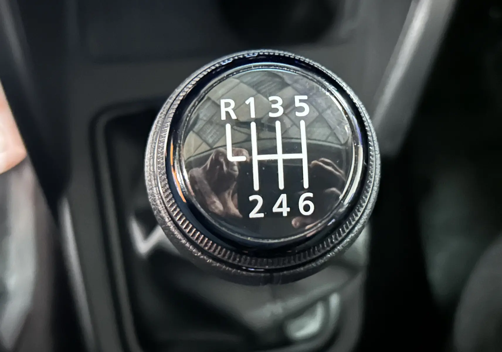 Gros plan sur le levier de vitesses manuel du Dacia Duster 2024, montrant les six rapports et la marche arrière.