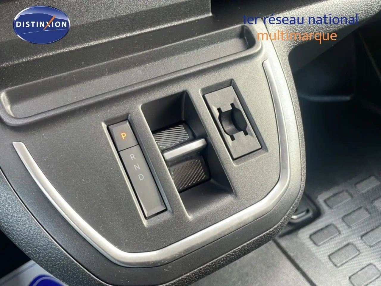 Gros plan sur la console centrale du Citroën Jumpy gris titane, montrant la commande de boîte automatique et un bouton rotatif.