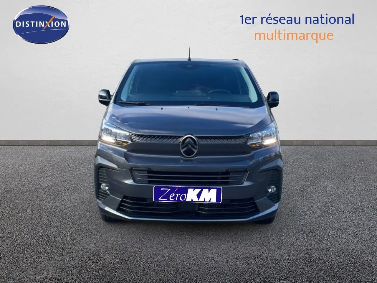 Vue frontale d'un Citroën Jumpy Van Long L3 gris titane métal avec calandre distinctive et phares allumés.