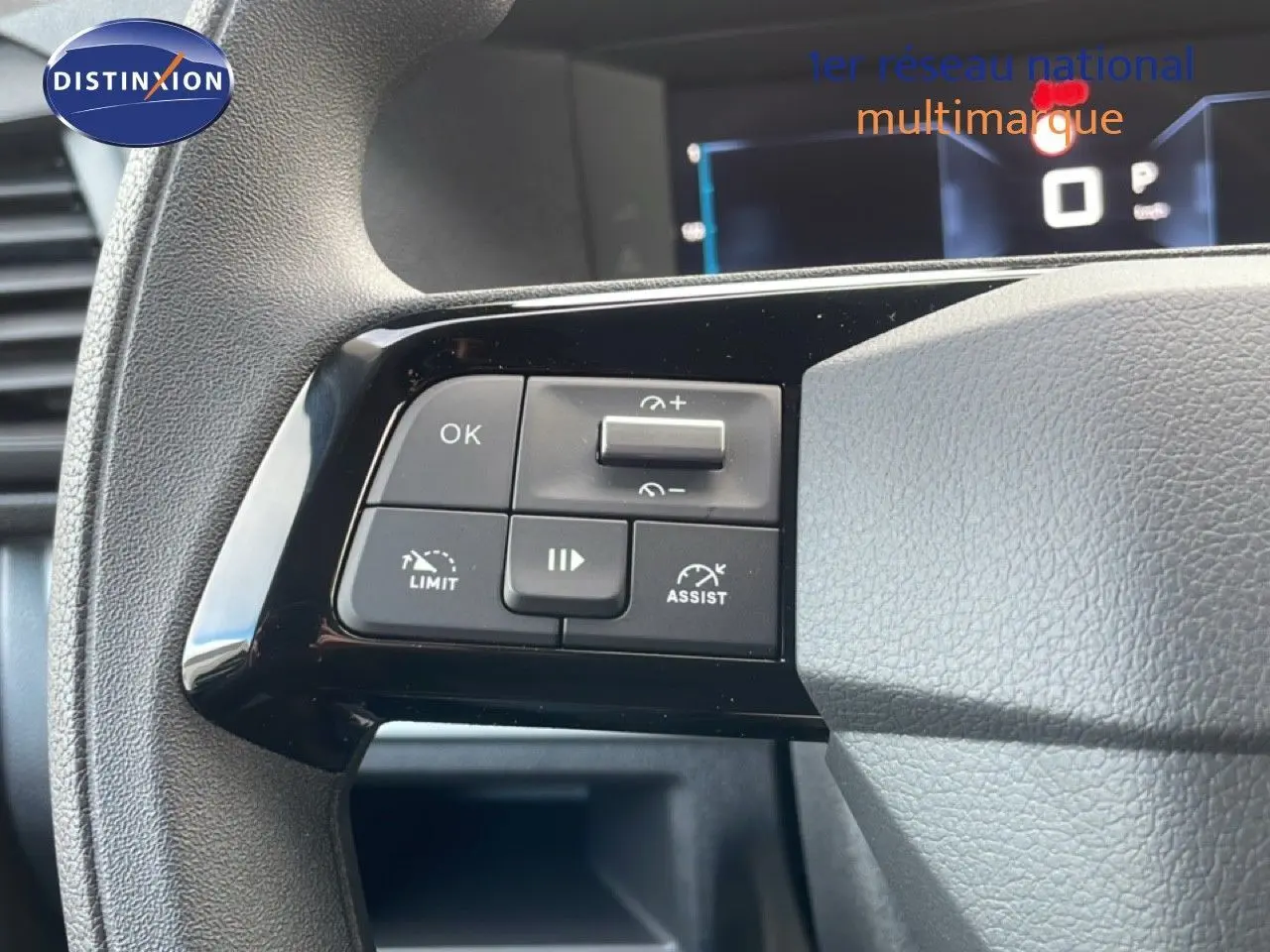 Gros plan sur les commandes au volant du Citroën Jumpy gris titane, mettant en valeur les boutons de régulateur et d'assistance.