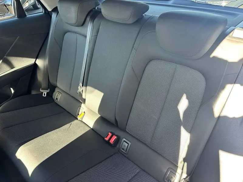 Vue intérieure de la banquette arrière noire de l'Audi Q2 35 TFSI 2023 avec appuie-têtes et ceintures visibles.