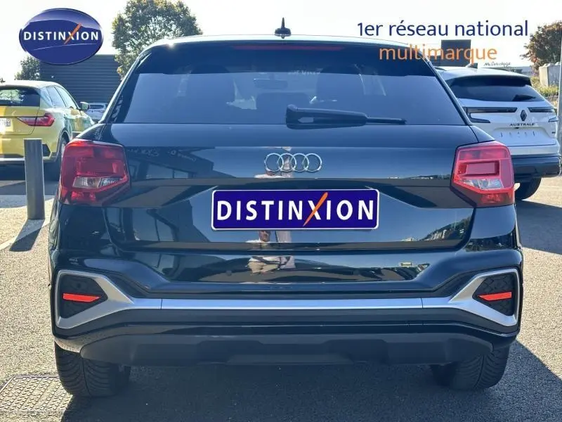Vue arrière d'un Audi Q2 noir avec feux arrière rouges et logo Audi centré sur le hayon.