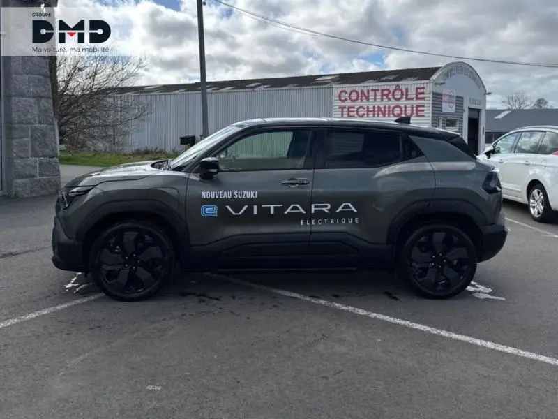 Vue de profil droit du Suzuki Vitara électrique 2026 en vert Land Breeze avec toit noir et jantes noires.