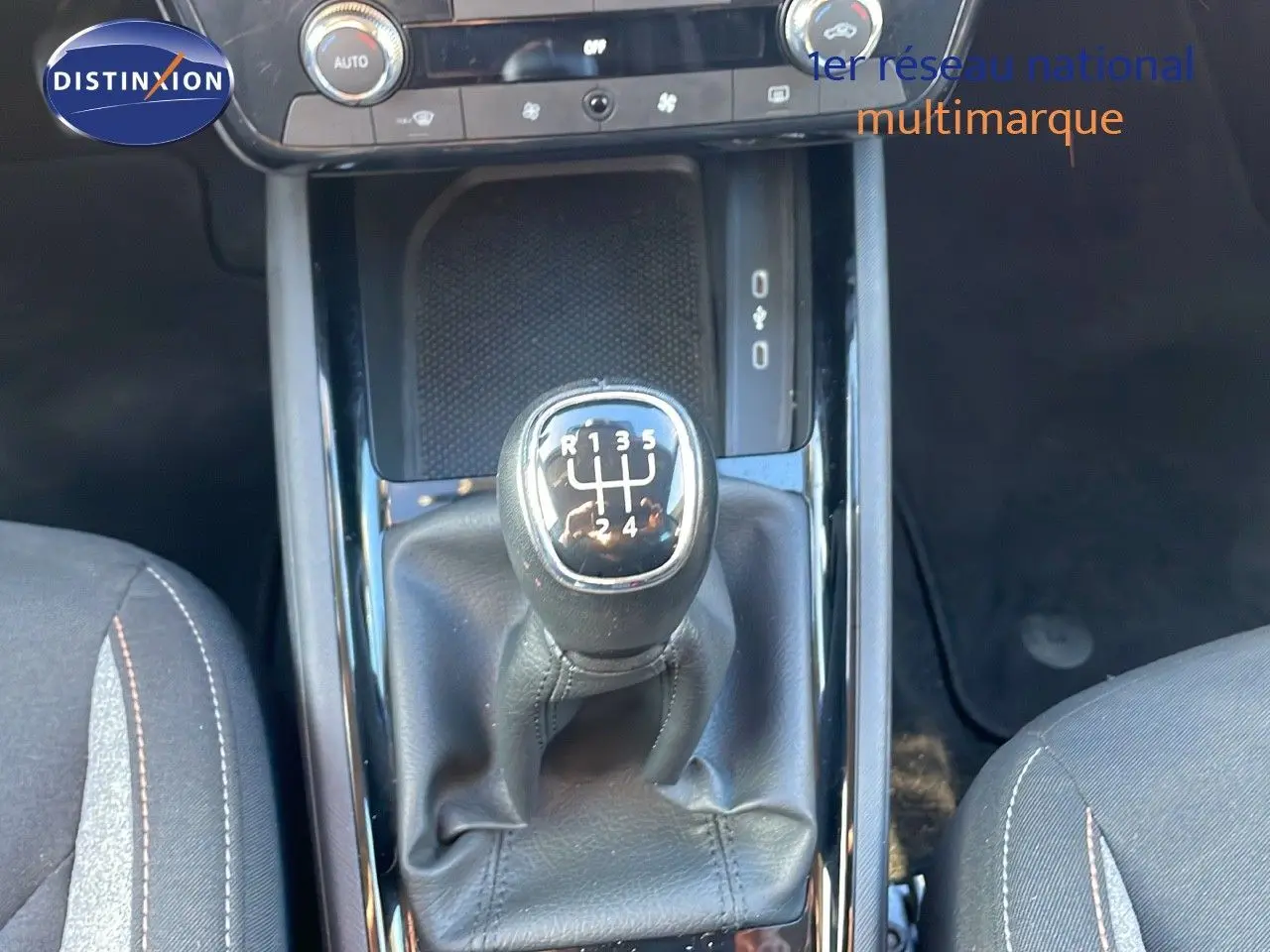 Le levier de vitesses manuel noir du Skoda Kamiq 2024, vu de dessus entre les sièges gris foncé.