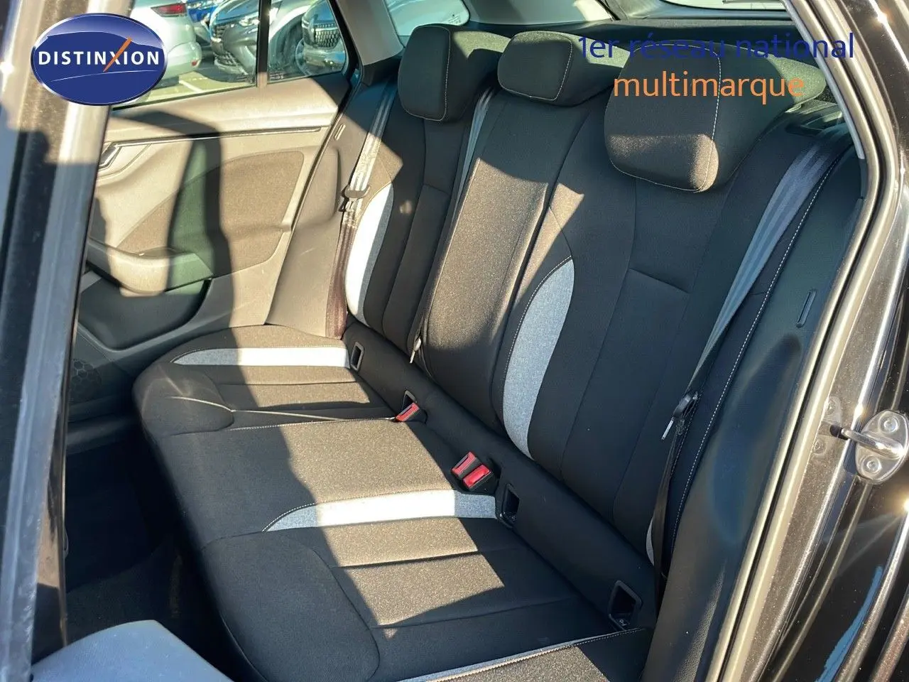 Vue intérieure côté arrière droit du Skoda Kamiq 2024 noir magique métal, montrant les sièges arrière en tissu gris et noir.