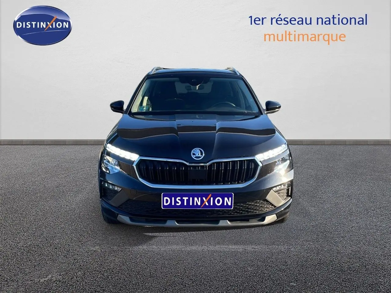 Vue de face du Skoda Kamiq noir magique métal 2024 avec calandre noire et feux LED allumés.