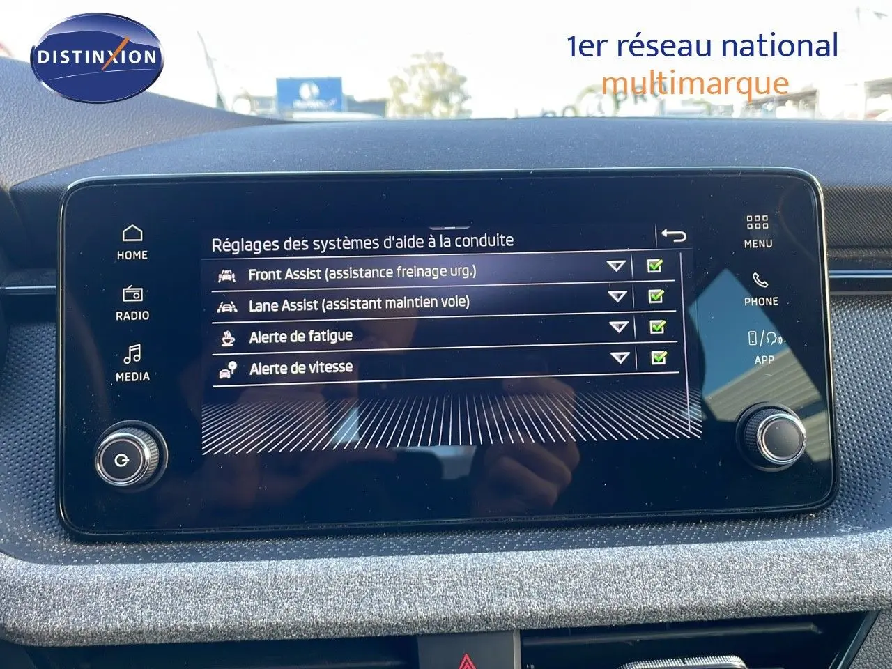 Écran tactile central affichant les réglages d'aide à la conduite du Skoda Kamiq noir magique métal, vue intérieure frontale.