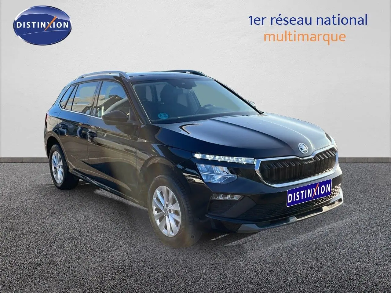 Vue 3/4 avant droite d'un Skoda Kamiq noir magique métal 2024 avec calandre chromée et jantes alliage.