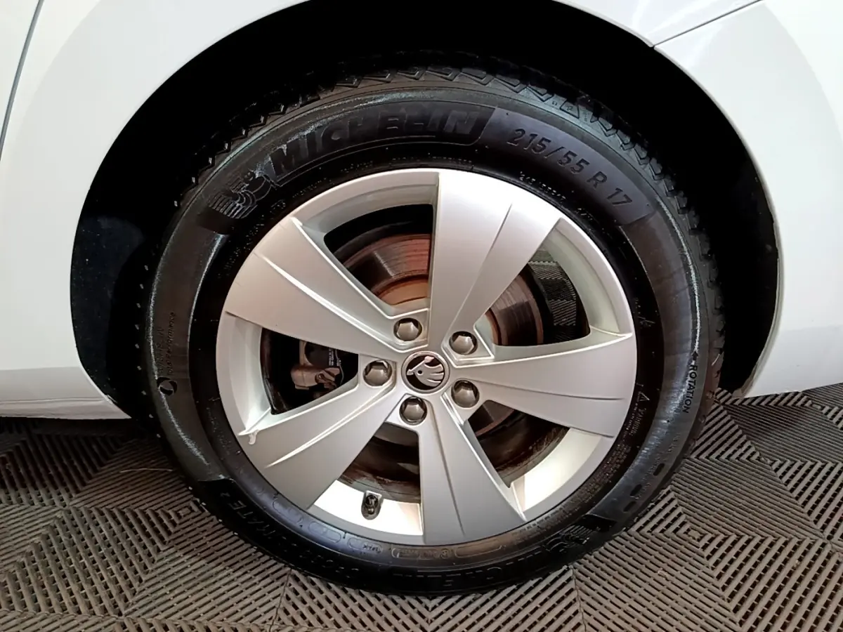Gros plan sur la roue avant droite de la Skoda Superb blanche, avec jante alliage et pneu Michelin visible.