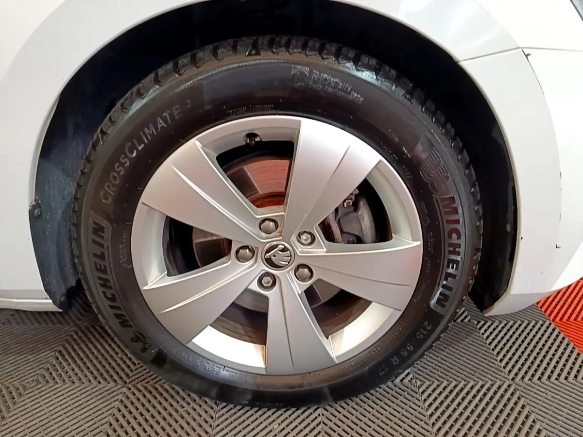 Gros plan sur la roue avant droite d'une Skoda Superb blanche, jante alliage et pneu Michelin CrossClimate 2.