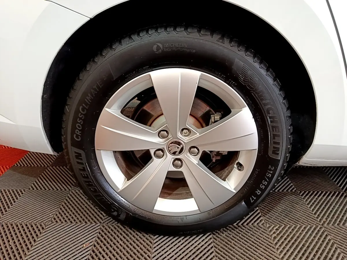 Gros plan sur la roue avant gauche d’une Skoda Superb blanche avec jante alliage cinq branches et pneu Michelin.