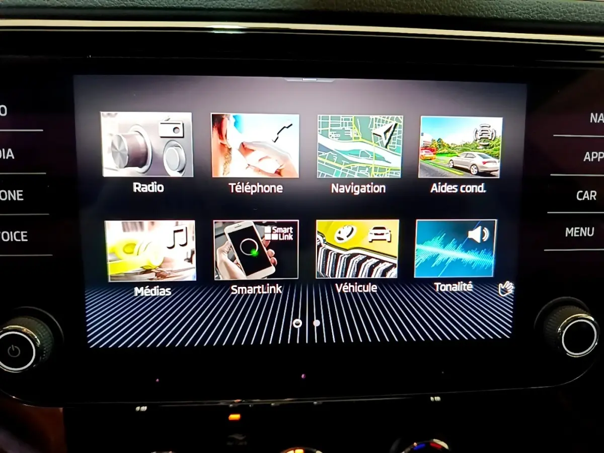 Écran tactile central affichant le menu multimédia de la Skoda Superb 2.0 TDI blanc, vue de face en intérieur.
