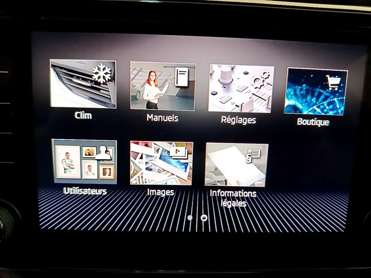 Écran tactile intérieur de la Skoda Superb blanc, affichant le menu principal avec icônes colorées.