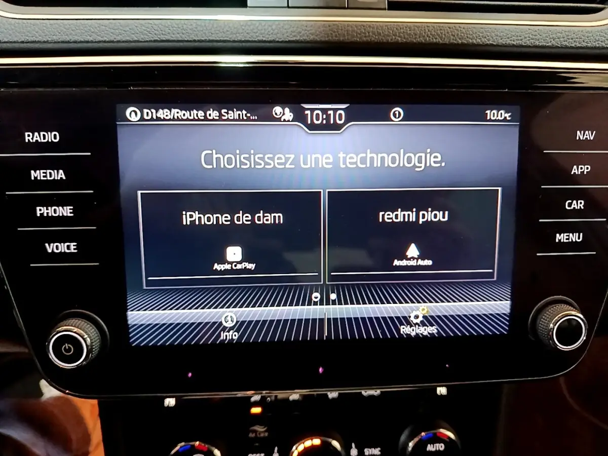 Écran tactile central de la Skoda Superb blanc, affichant le choix entre Apple CarPlay et Android Auto.