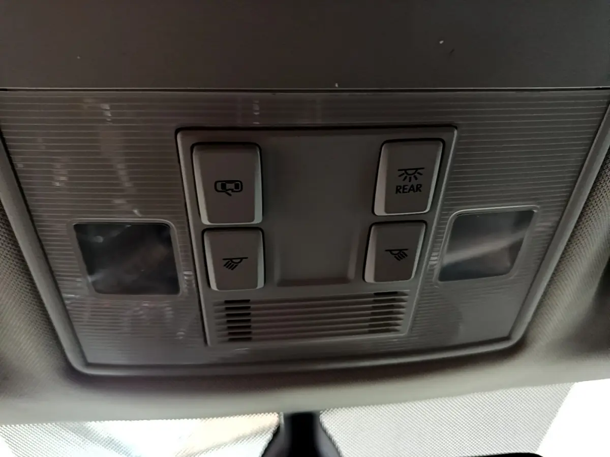 Plafonnier intérieur avec commandes d’éclairage et de toit ouvrant dans une Skoda Superb blanche, vue de dessous.