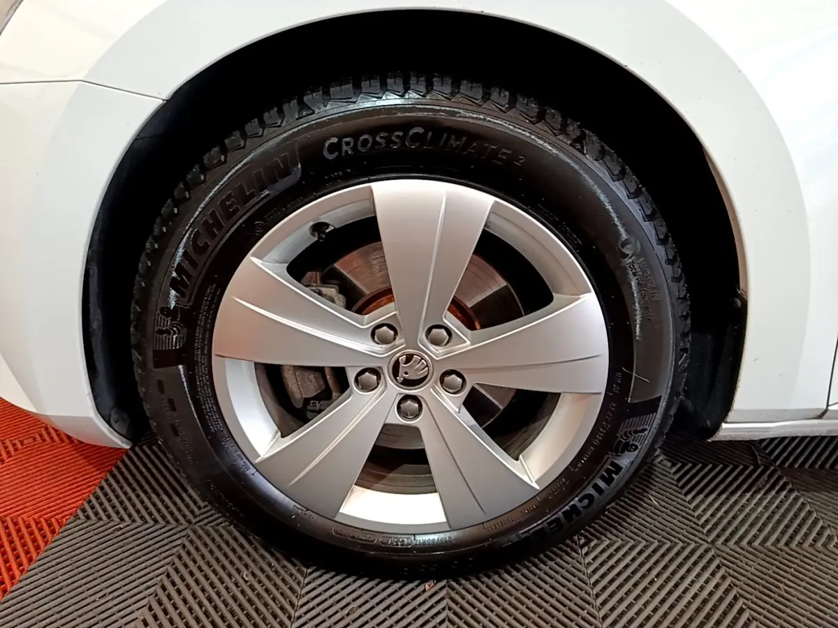 Gros plan sur la roue avant droite d’une Skoda Superb blanche, jante alliage argent et pneu Michelin CrossClimate 2.