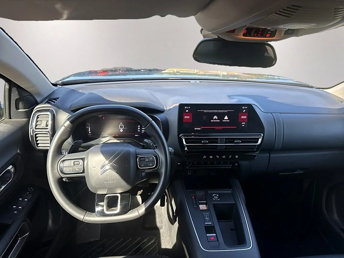 Vue intérieure avant du tableau de bord noir du Citroën C5 Aircross 2025 avec volant multifonction et écran tactile central.