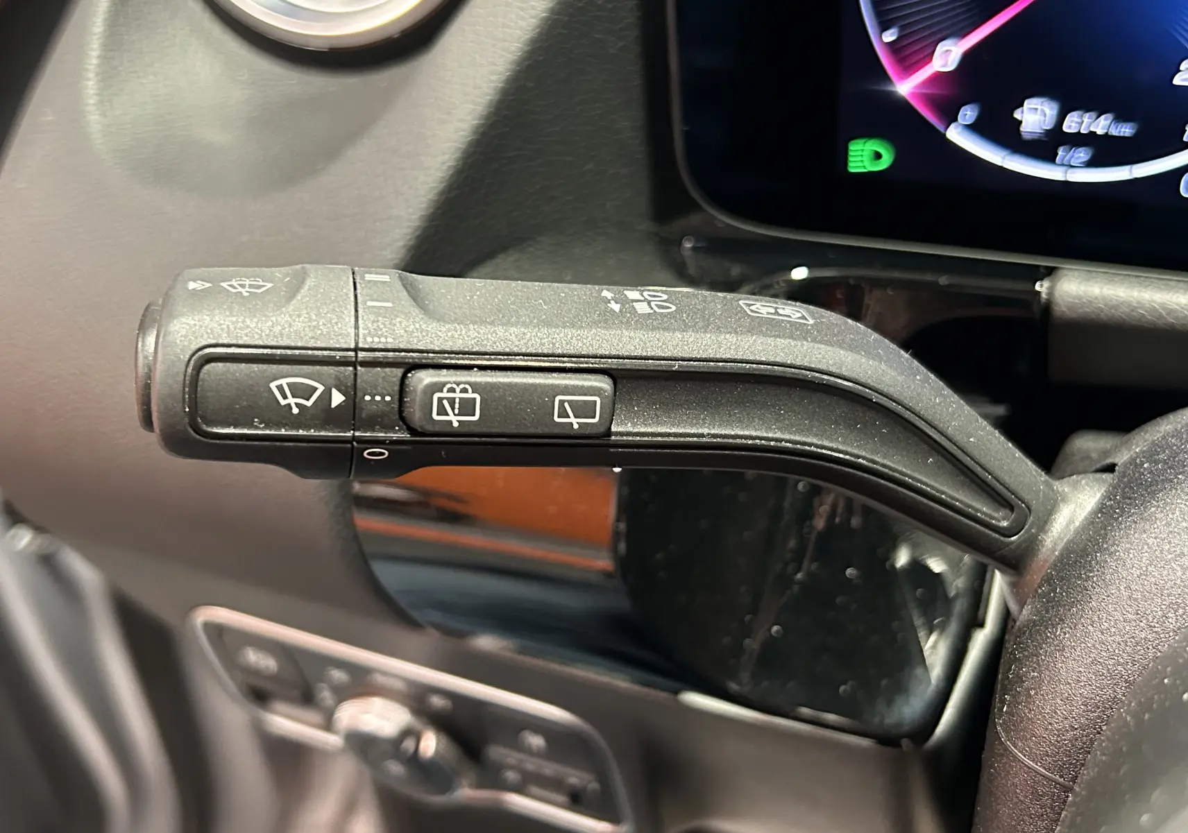 Gros plan sur la commande d’essuie-glace à gauche du volant dans l’habitacle du Mercedes GLA 200 D argent High-tech 2024