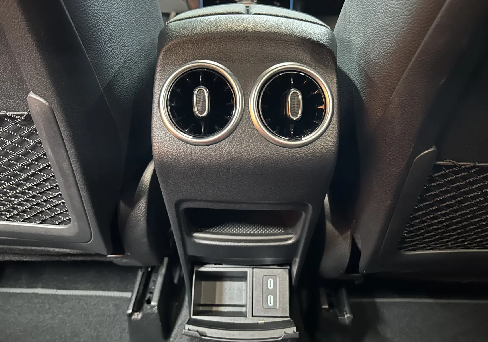 Vue rapprochée des aérateurs arrière et prise USB du Mercedes GLA 200 D AMG Line 2024 en intérieur noir.