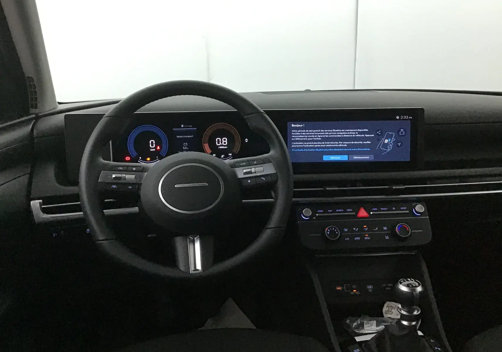 Vue intérieure du tableau de bord du Hyundai Tucson 2025, avec volant cuir, écran digital large et levier de vitesse manuel.