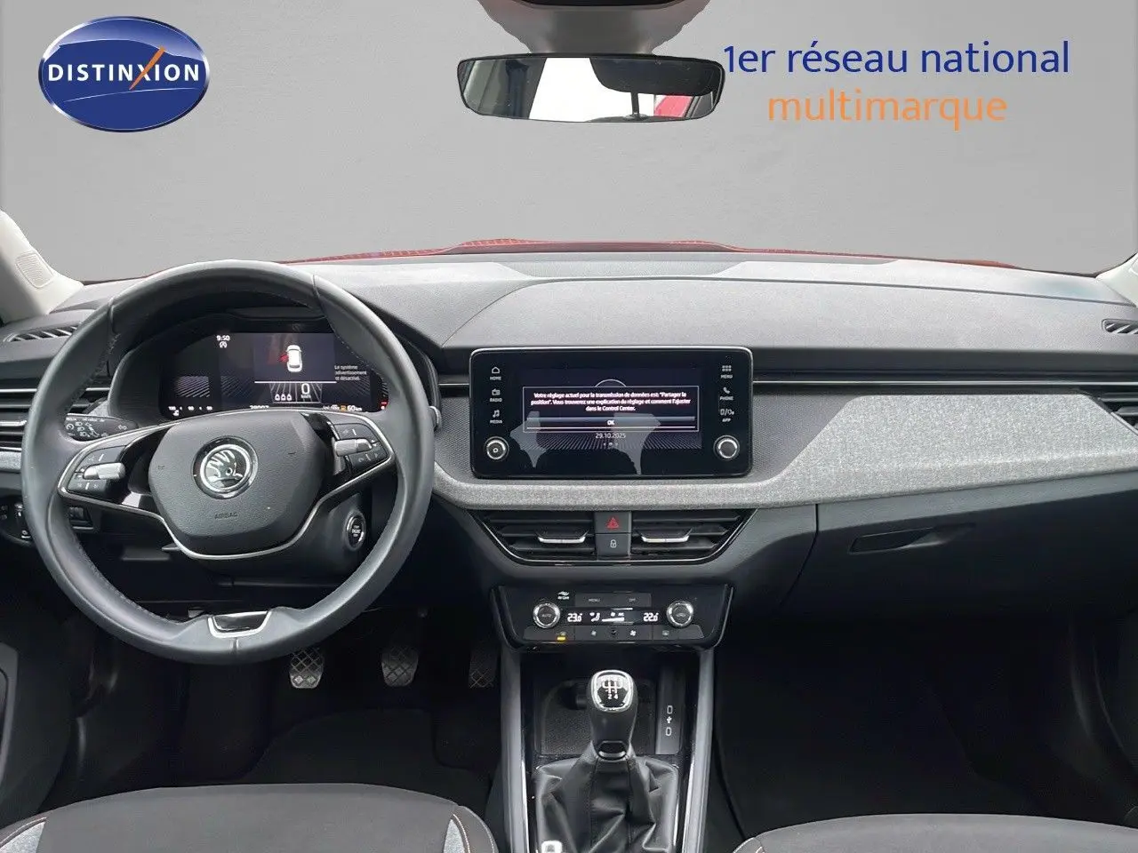 Intérieur de la Skoda Kamiq 2024 rouge velvet metal, vue frontale sur le tableau de bord et levier de vitesse manuel.