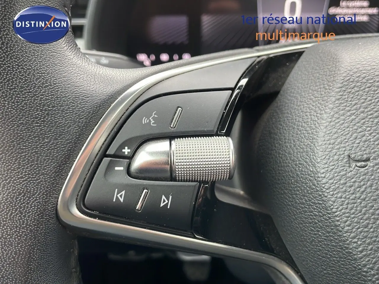 Gros plan sur les commandes gauche du volant en cuir noir du Skoda Kamiq 2024 rouge Velvet Metal.