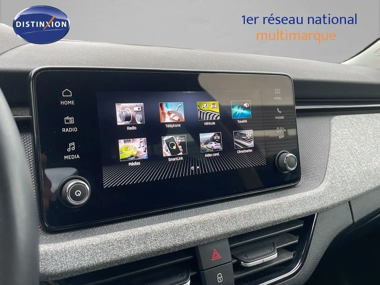 Écran tactile central du tableau de bord du Skoda Kamiq rouge Velvet Metal, affichant les menus multimédias et connectivité.