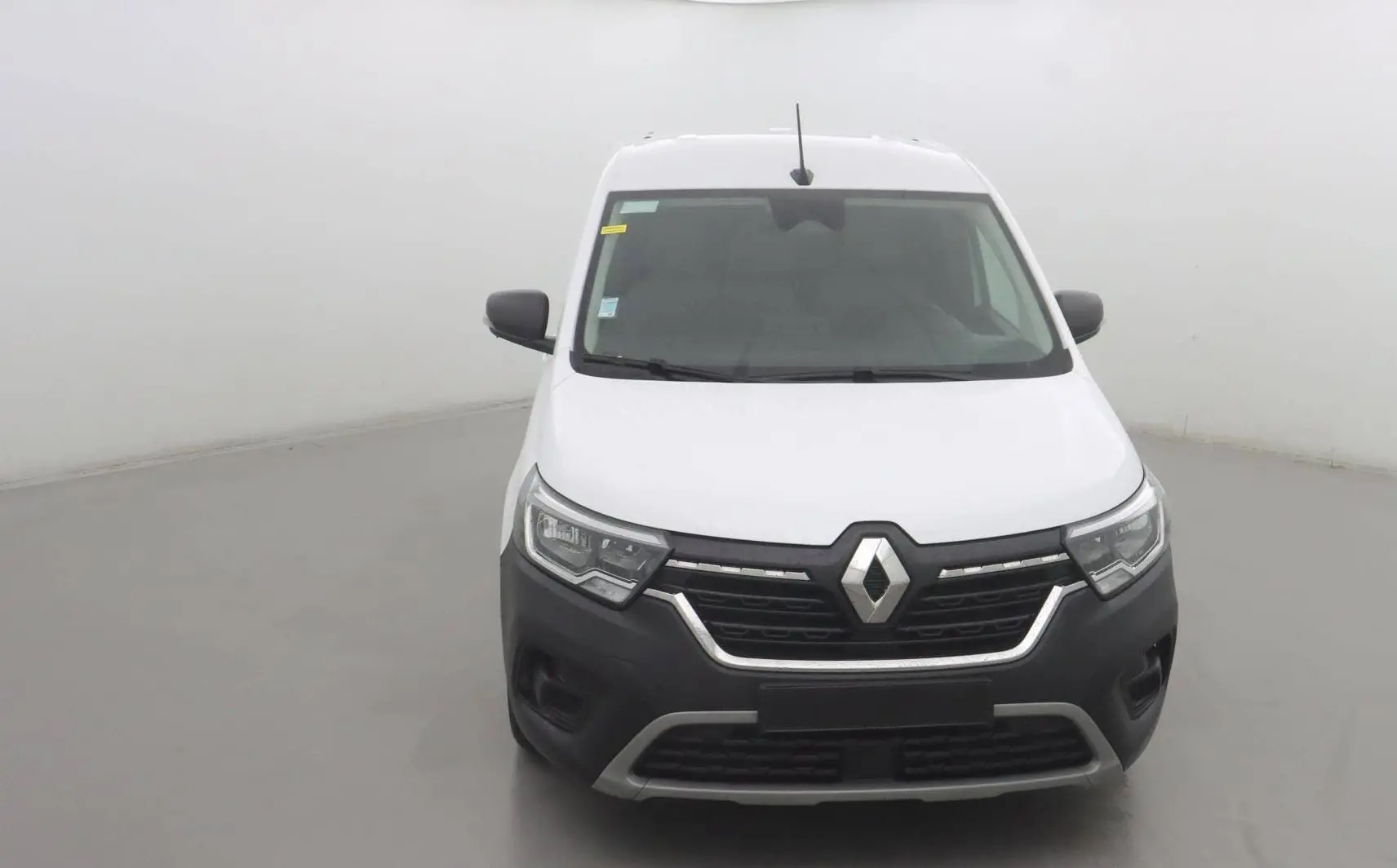 Renault Kangoo Van blanc vue de face, avec calandre noire et détails chromés sur un fond neutre.