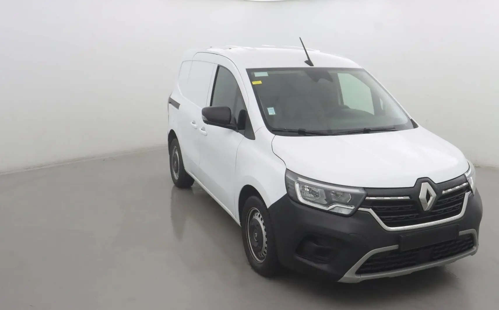 Renault Kangoo Van blanc vue 3/4 avant droit avec pare-chocs noir et calandre distinctive 2024.