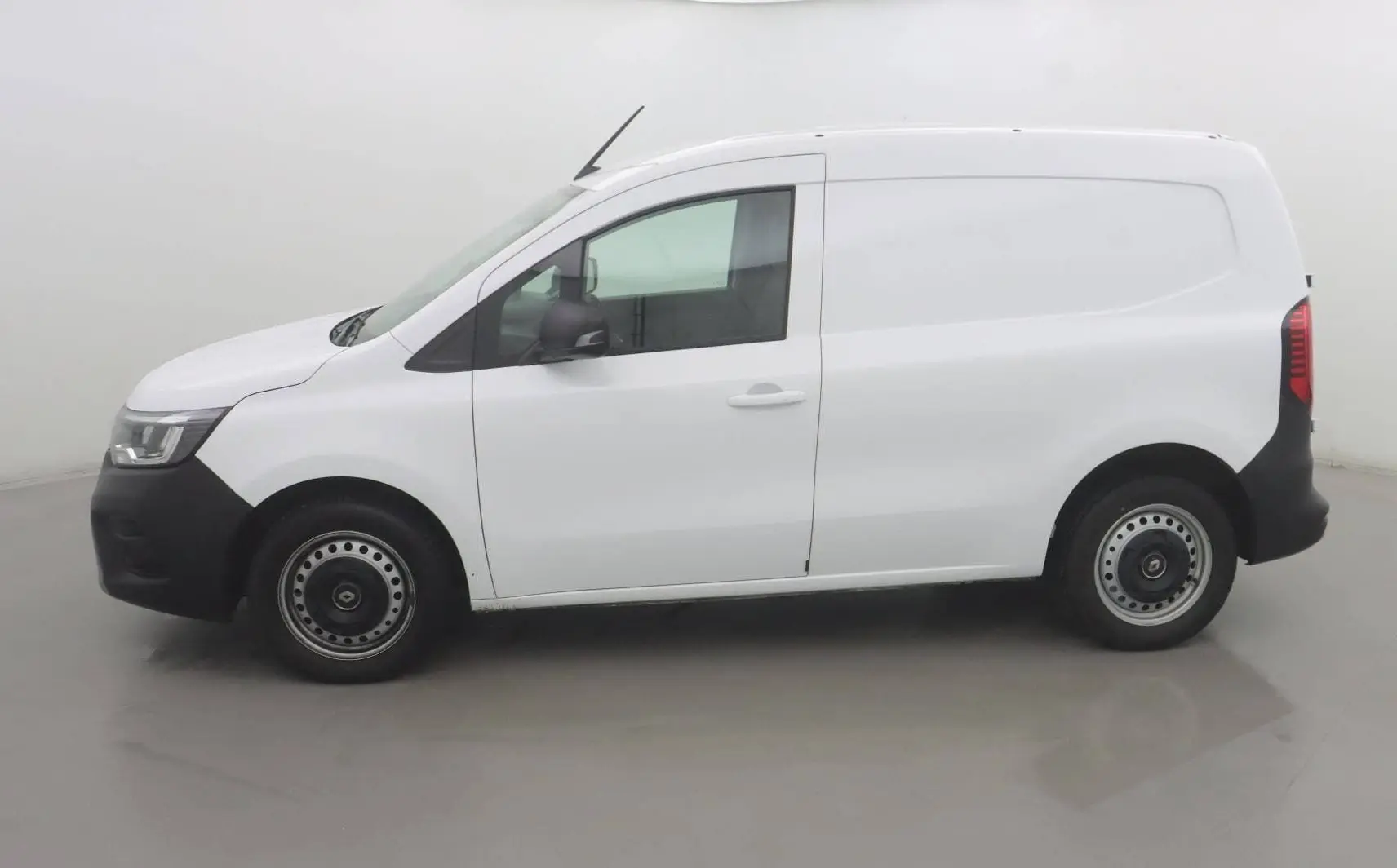 Profil droit d’un Renault Kangoo Van blanc 2024 avec pare-chocs noirs et jantes acier en environnement neutre.