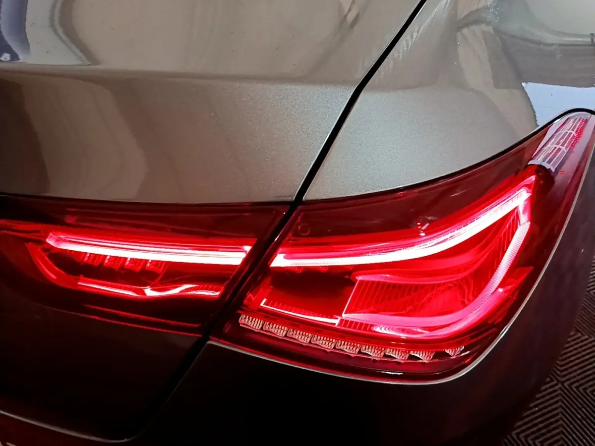 Gros plan sur le feu arrière droit rouge d'une Mercedes CLA 180 d Business Line gris clair 2021.