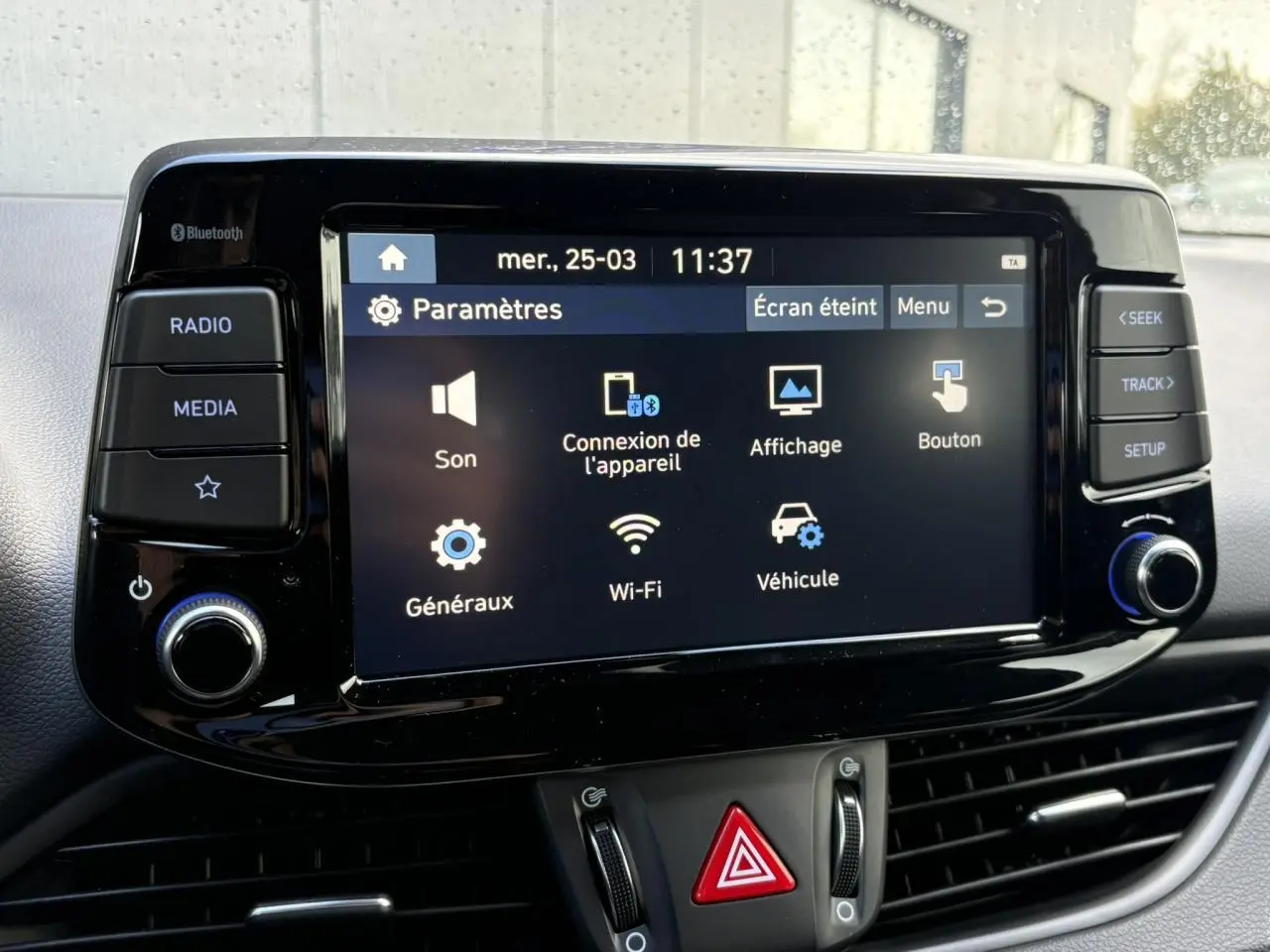 Écran tactile central du Hyundai i30 SW T-GDI 120 Modern affichant le menu paramètres, avec commandes autour.