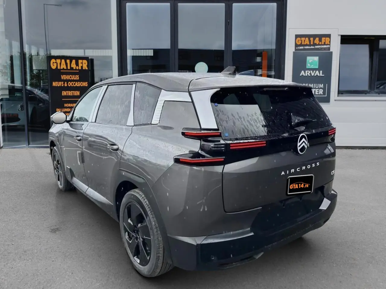 Vue 3/4 arrière droite d'un Citroën C5 Aircross gris platinium avec feux arrière horizontaux et jantes noires.