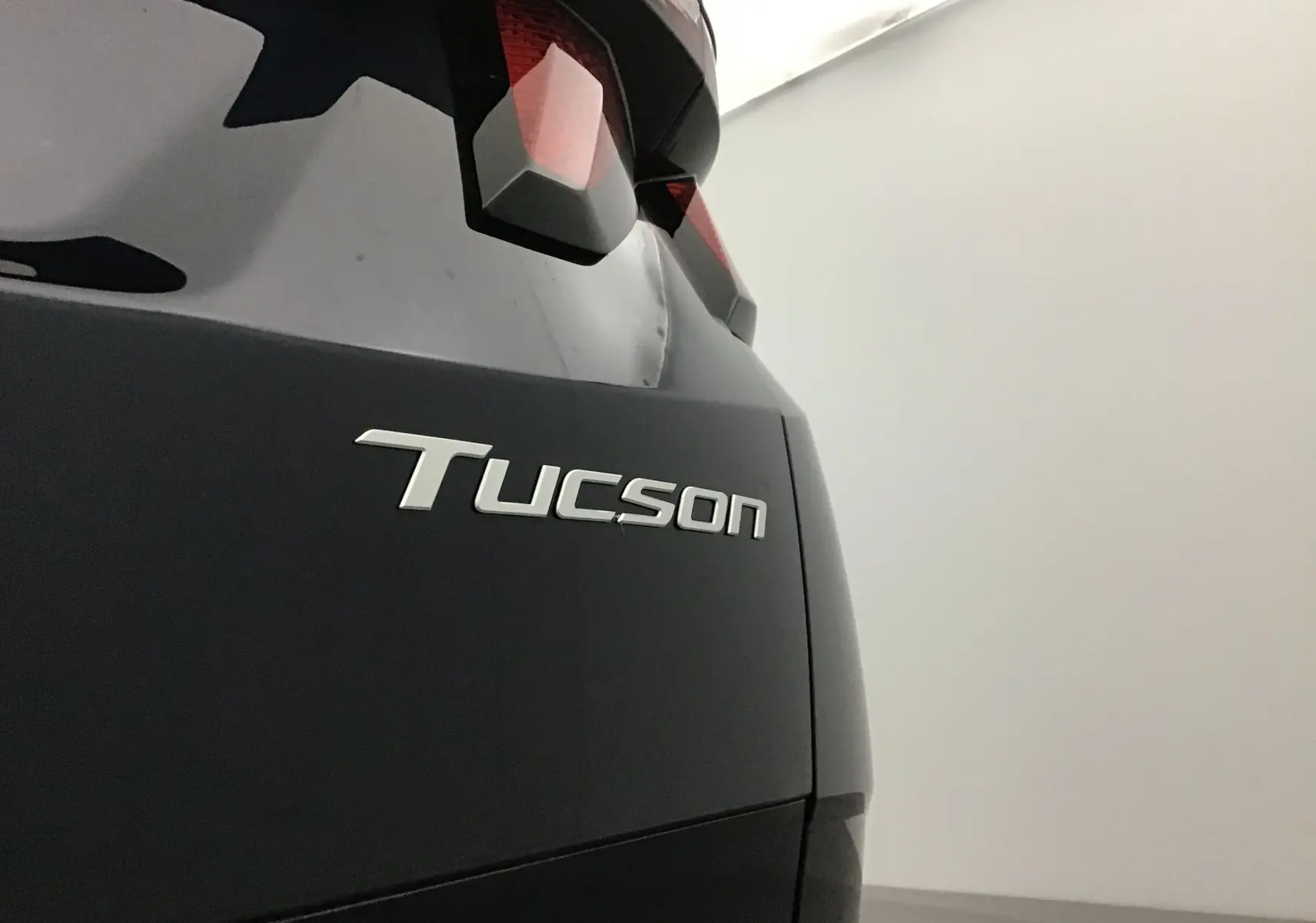 Gros plan sur l'arrière droit du Hyundai Tucson bleu Salling, mettant en valeur le logo et le feu arrière.