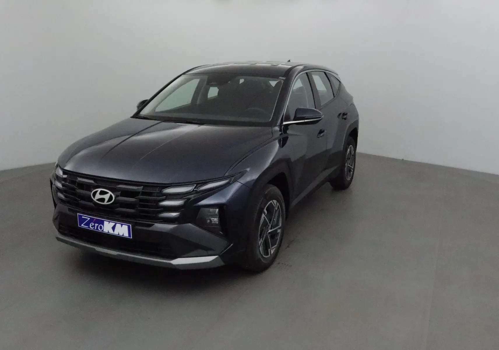Hyundai Tucson 2025 bleu Salling vu en 3/4 avant droit, avec calandre noire et jantes alliage 17 pouces.