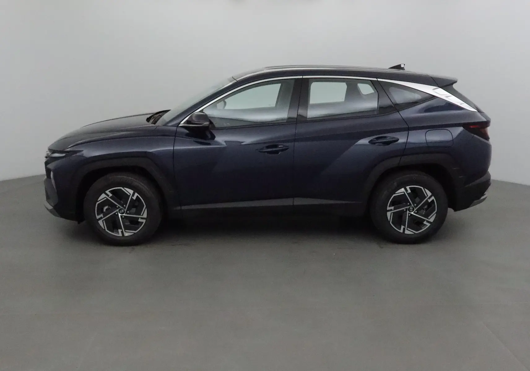 Hyundai Tucson 2025 bleu salling vu de profil côté gauche, avec jantes alliage 17 pouces et lignes modernes.